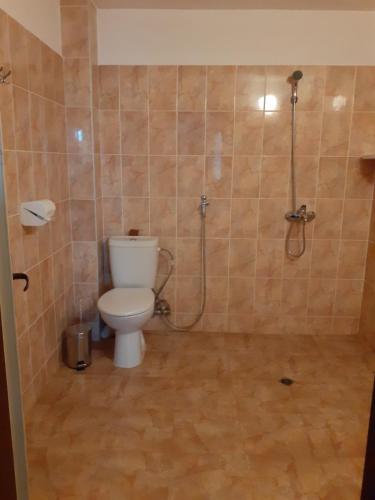 uma casa de banho com um WC e um chuveiro em СТАИ ЗА ГОСТИ ПОДКОВА em Shabla