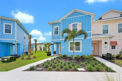 a blue house with palm trees in a yard at Margaritaville Cottages Orlando with H2O Waterpark by Rentyl in Kissimmee