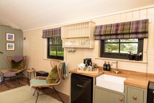 uma cozinha com um lavatório e duas cadeiras em The Hide at Woodside em St. Andrews