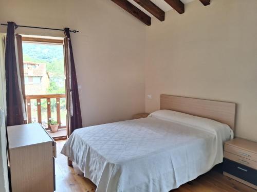 a bedroom with a bed and a large window at La casa de Omi in Camaleño