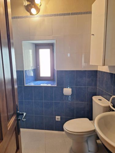 a bathroom with a toilet and a sink and a window at La casa de Omi in Camaleño