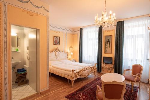 1 dormitorio con cama y lámpara de araña en Pension Bellevue, en Múnich