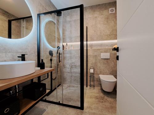 een badkamer met een wastafel en een glazen douche bij Studio apartment SeaDream - 50 meters from the sea in Brodarica