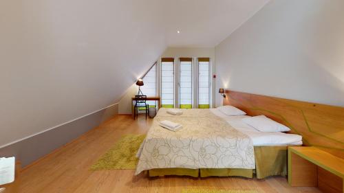 a bedroom with a large bed with a wooden headboard at Kassari Apartment in Hiiumaa