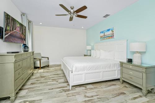 a bedroom with a white bed and a ceiling fan at Margaritaville Cottages Orlando with H2O Waterpark by Rentyl in Kissimmee