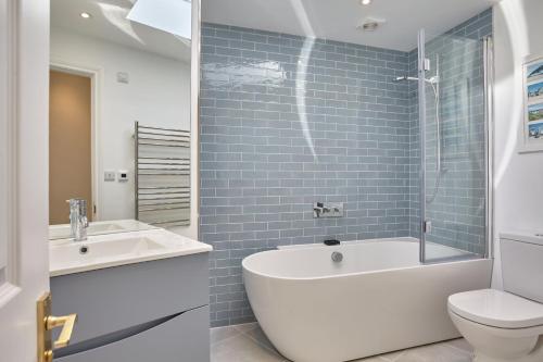 a bathroom with a tub and a sink and a toilet at Meadowside in Saint Mawes