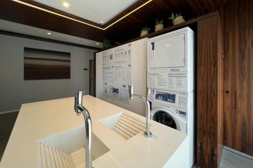 a kitchen with a washer and a washing machine at Zainalofts7 Moema - 1km Ibira e 200m metrô 602 ID in São Paulo