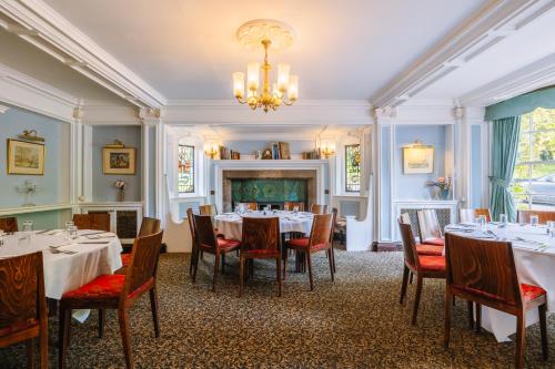 a dining room with tables and chairs and a chandelier at Muthu Belstead Brook Hotel in Ipswich