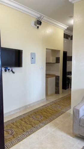 ein Wohnzimmer mit einem Flachbildfernseher an der Wand in der Unterkunft العاصفة in Chamis Muschait