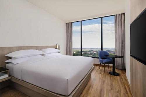 a hotel room with a bed and a desk and a window at Fairfield by Marriott Jakarta Soekarno-Hatta Airport in Tangerang