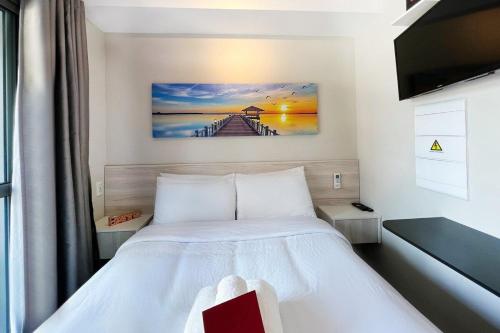 1 dormitorio con 1 cama y una pintura en la pared en Zainalofts7 Moema - 1km Ibira e 200m metrô 202 ID, en São Paulo