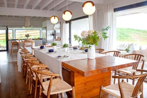uma grande sala de jantar com uma grande mesa e cadeiras em Villa sublime con piscina climatizada y vistas em Prellezo