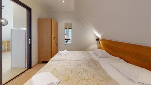 Schlafzimmer mit einem großen Bett mit einem Kopfteil aus Holz in der Unterkunft Kassari Apartment in Hiiumaa