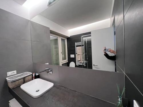 een persoon die een foto neemt van een badkamerspiegel bij Appartamento di design con terrazza privata in Rome