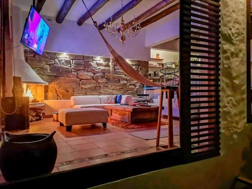 a living room with a couch and a stone wall at casa colores de la montaña in Villa de Leyva
