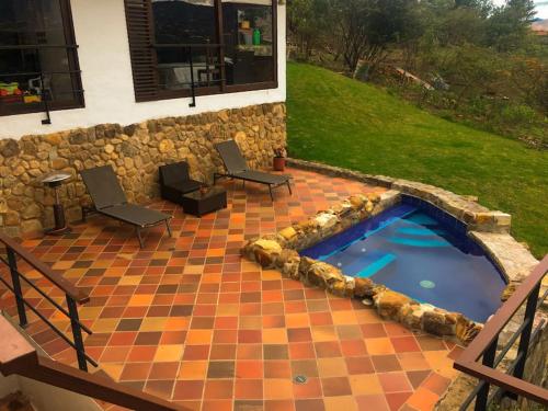 a patio with a pool and chairs and a house at casa colores de la montaña in Villa de Leyva