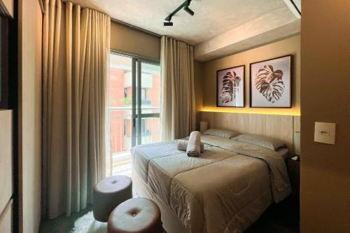 1 dormitorio con cama y ventana grande en Zainalofts7 Moema - 1km Ibira e 200m metrô 1009 ID, en São Paulo