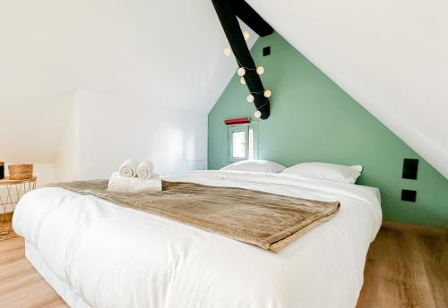 um quarto com uma cama branca e uma parede verde em Flamant Rose em Annecy