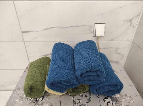 una pila de toallas sentadas en un estante en un baño en Hostel Horgos Centar en Horgoš