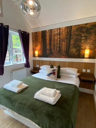 - une chambre avec un lit et 2 serviettes dans l'établissement Hare Lodge with Hot Tub, à Cupar