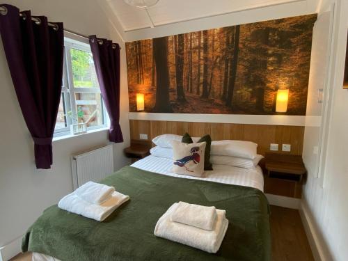 a bedroom with a bed with two towels on it at Hare Lodge with Hot Tub in Cupar