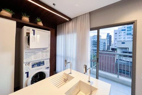 baño con lavadora y ventana en Zainalofts7 Moema - 1km Ibira e 200m metrô 507 ID, en São Paulo