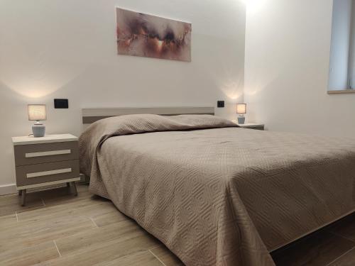 ein Schlafzimmer mit einem Bett und einem Nachttisch mit zwei Lampen in der Unterkunft Casa Venere in Ospedaletto