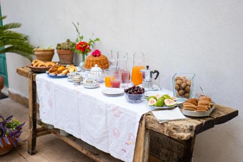 a table with breakfast foods and orange juice on it at Radici Dimora natura cultura in Campagnola