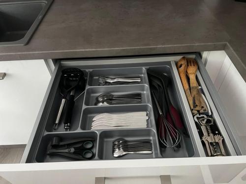a drawer in a kitchen with utensils in it at Ferienwohnung: Waldblick in Hatten