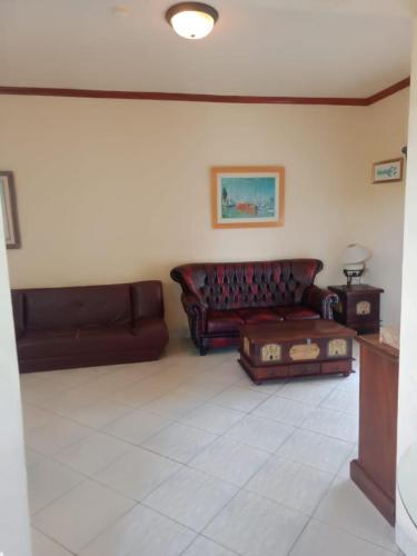 a living room with two brown leather couches at Apartment Marbella Anyer in Serang