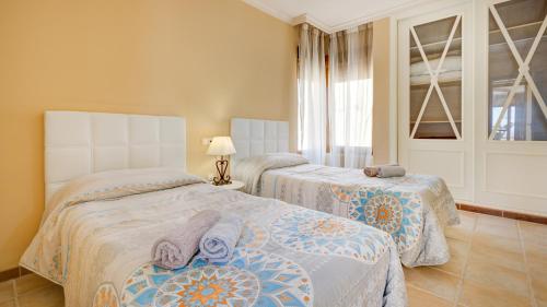 a bedroom with two beds and a window at Men Men in Caleta De Fuste