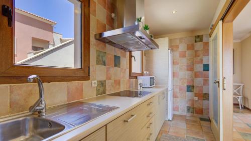 a kitchen with a sink and a mirror at Men Men in Caleta De Fuste