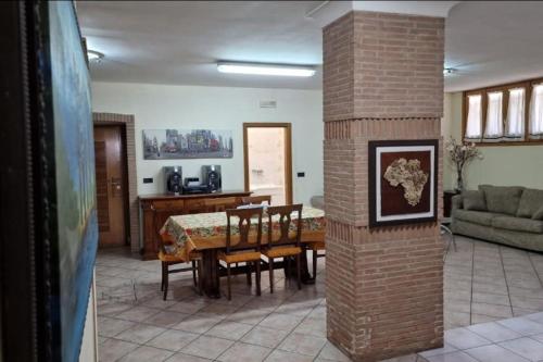 ein Wohnzimmer mit Tisch und Stühlen und einer Ziegelsäule in der Unterkunft Casa Erre in Lusciano