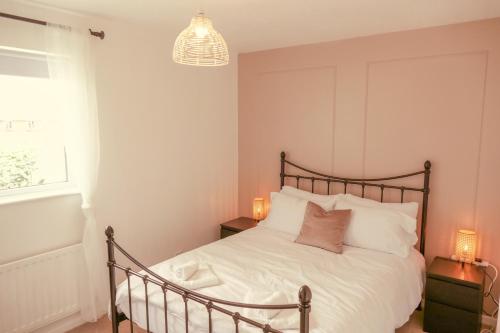 Un dormitorio con una cama con sábanas blancas y una lámpara de araña. en Home in Longwell Green, en Warmley