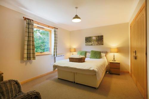 a bedroom with a bed and a window at Honeysuckle, Colvend in Rockcliffe