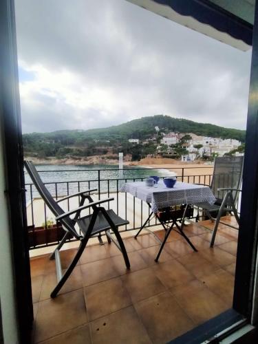 balcón con mesa, sillas y vistas al agua en Patxei en Tamariu