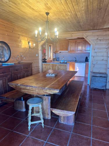 a kitchen with a large wooden table and benches at Chalé Inn Star in Penhas da Saúde