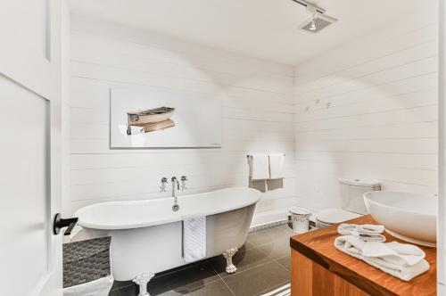 baño blanco con bañera y aseo en 454 Hotel du Lac - Cozy 2BR Condo w Stunning Mountain & Lake Views, en Mont-Tremblant