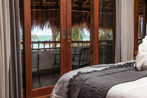 a bedroom with a bed and a view of the ocean at Amaite Holbox - Oceanfront Hotel in Holbox Island