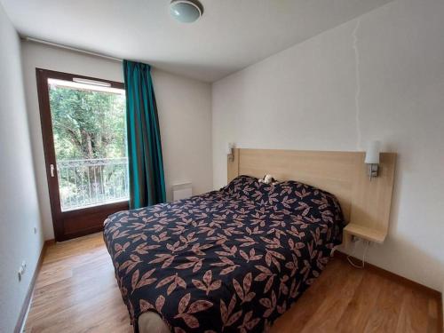 une chambre avec un lit et une fenêtre dans l'établissement Les Jardins de Ramel -appart.T2, à Luchon