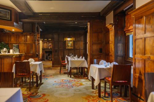 a dining room with tables and chairs in a restaurant at Muthu Belstead Brook Hotel in Ipswich