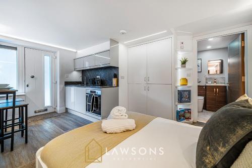 a kitchen and living room with a bed and a table at Cosy Living by Lawsons in Windsor