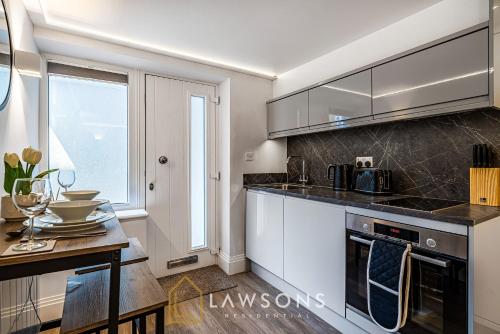 a kitchen with white cabinets and a counter top at Cosy Living by Lawsons in Windsor