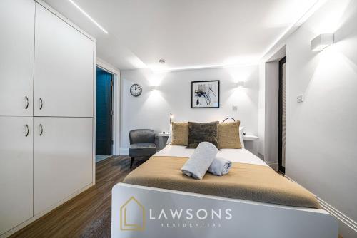 a white bedroom with a bed and a chair at Cosy Living by Lawsons in Windsor