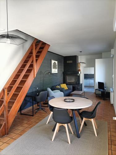 un salon avec une table et des chaises et un escalier dans l'établissement Maison 3 chambres - Chez Florence, à Yzeure