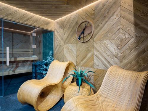 a room with two chairs and a clock on a wall at Apartamenty Górski Prestige in Białka Tatrzanska