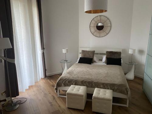 1 dormitorio con 1 cama con 2 taburetes y espejo en Eur Centro lux apartment con camino, en Roma