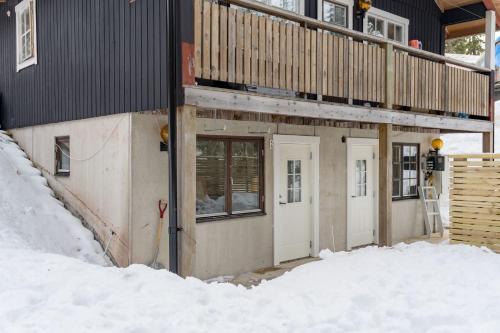 a house with a deck on the side of it in the snow at Apartment in Lindvallen in Sälen