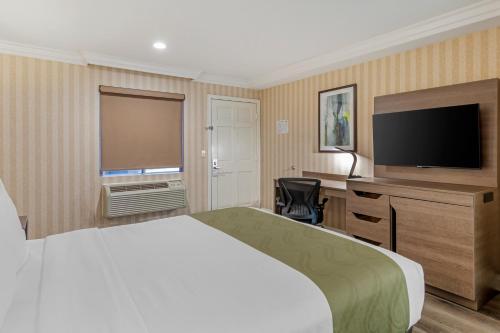 a hotel room with a bed and a flat screen tv at Quality Inn & Suites Anaheim Maingate in Anaheim