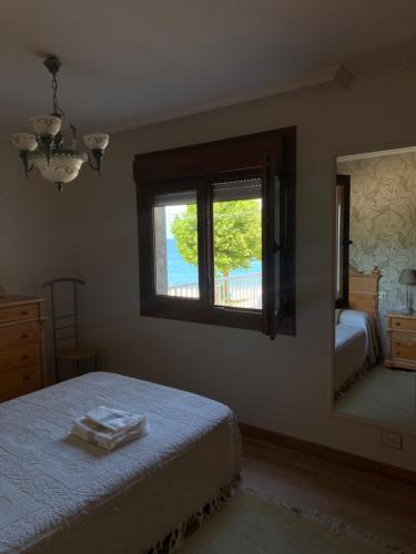 Schlafzimmer mit einem Bett, einem Fenster und einem Spiegel in der Unterkunft Agrelo Playa in Bueu